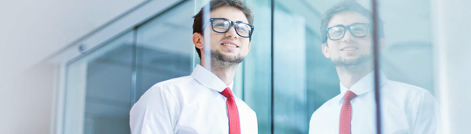 Man with glasses looking through a window
