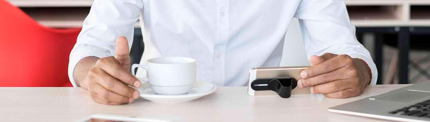 Man drinking coffee in front of a laptop