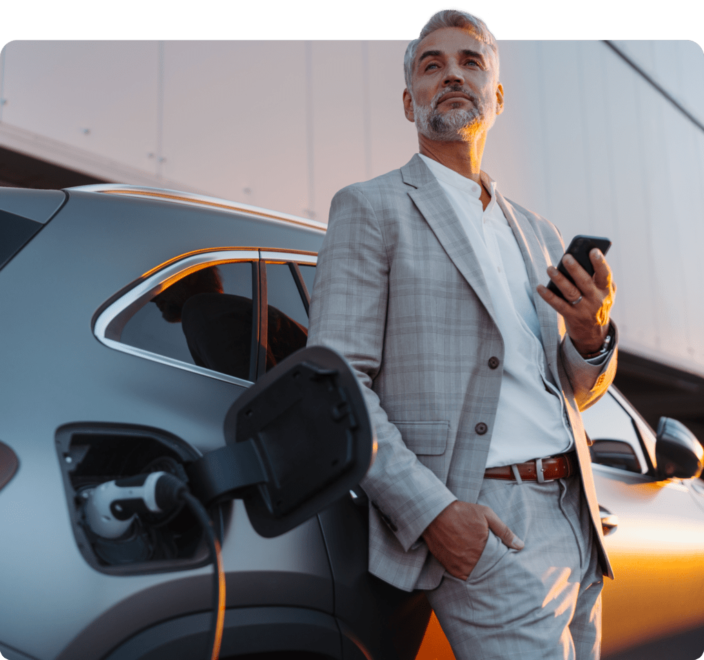 Man speaking on a phone while charging an electric car