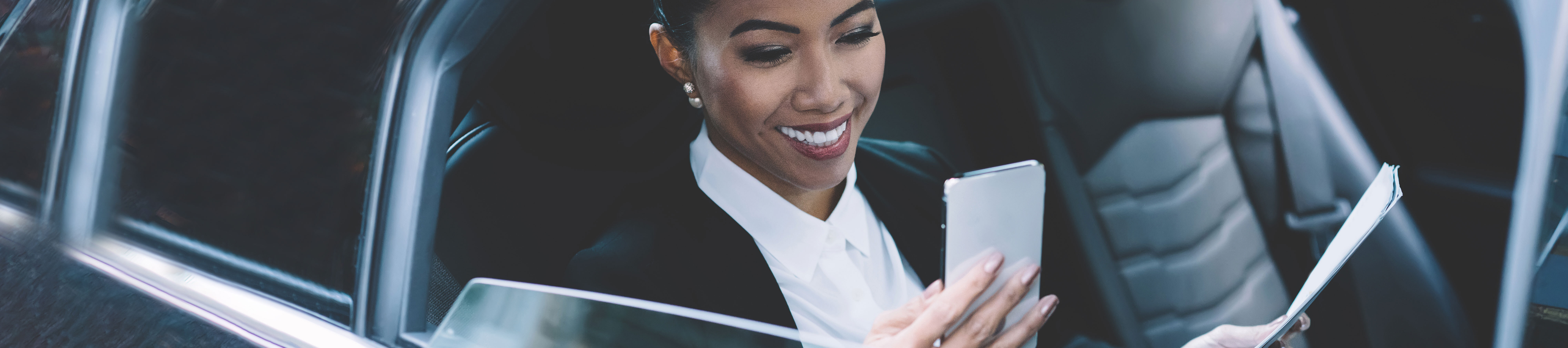 Woman in a car checking her phone
